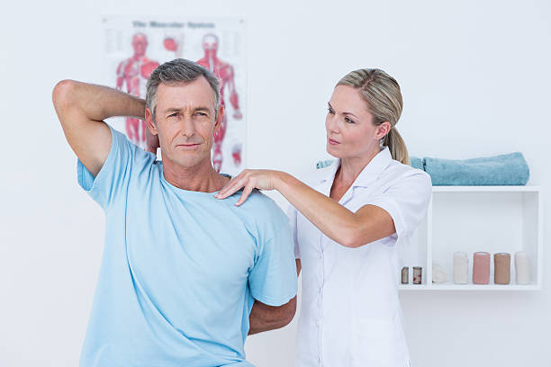 Doctor stretching a man arm in medical office