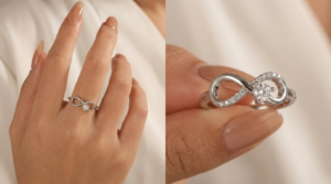 Close-up of a white gold infinity ring featuring a round diamond and pavé accents, worn on a hand and displayed in detail.