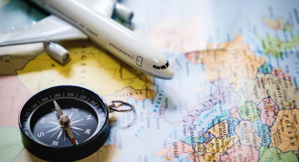 selective-focus-miniature-tourist-compass-map-with-plastic-toy-airplane-abstract-background-travel-concept