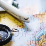 selective-focus-miniature-tourist-compass-map-with-plastic-toy-airplane-abstract-background-travel-concept
