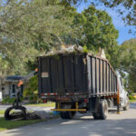 Bulk truck picking up trash in a community street, Plantation, Florida, USA