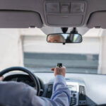 Man In Car Using Remote Control To Open The Automatic Garage Door