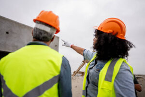 Construction workers talking and analyzing building site