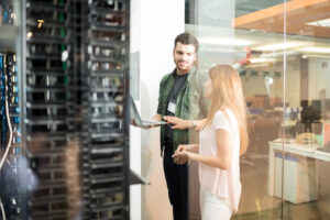two-business-people-standing-server-room-with-laptop-discussing-300x200.jpg